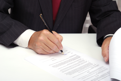 Image of man signing document